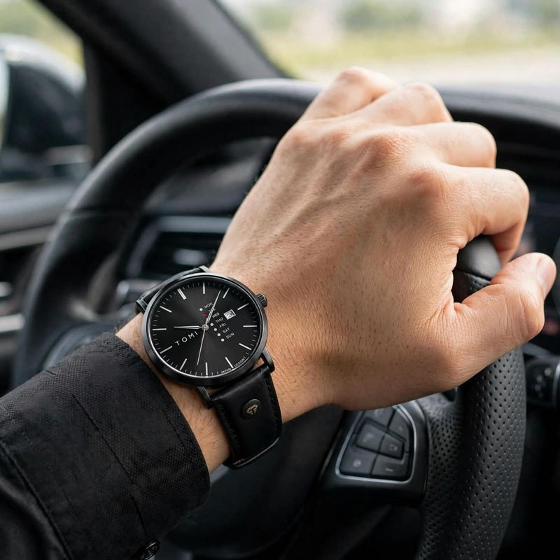 mens black leather watch with minimalist dial worn while driving