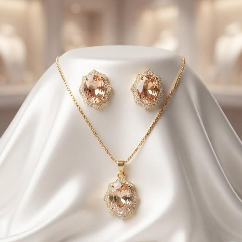 gold oval crystal jewelry set with pendant necklace and matching earrings displayed on silk