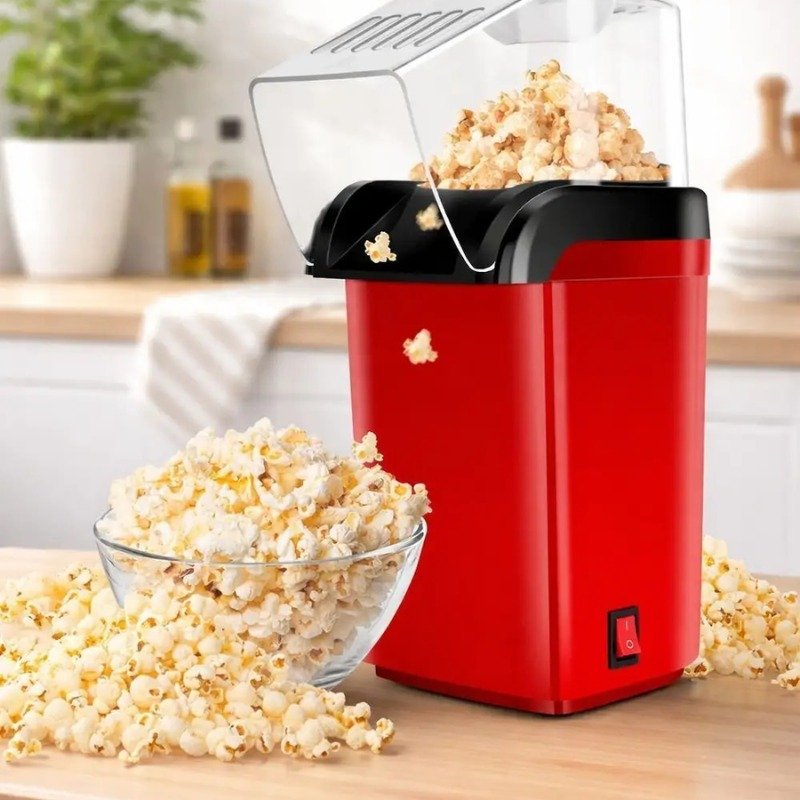 Red electric popcorn maker preparing fresh popcorn at home