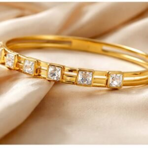 Gold crystal bangle bracelet featuring square-cut sparkling stones on satin fabric